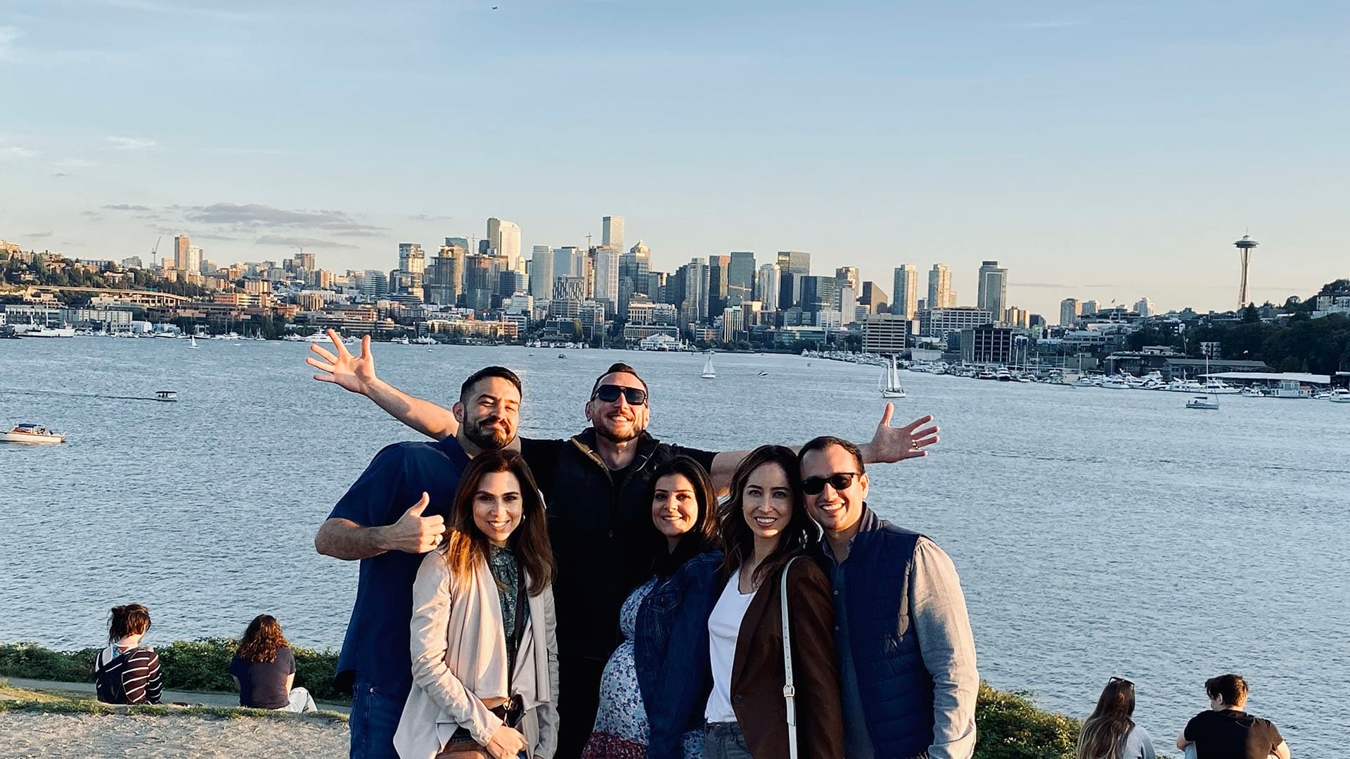 Friends posing with Seattle skyline and Elliott Bay waterfront view