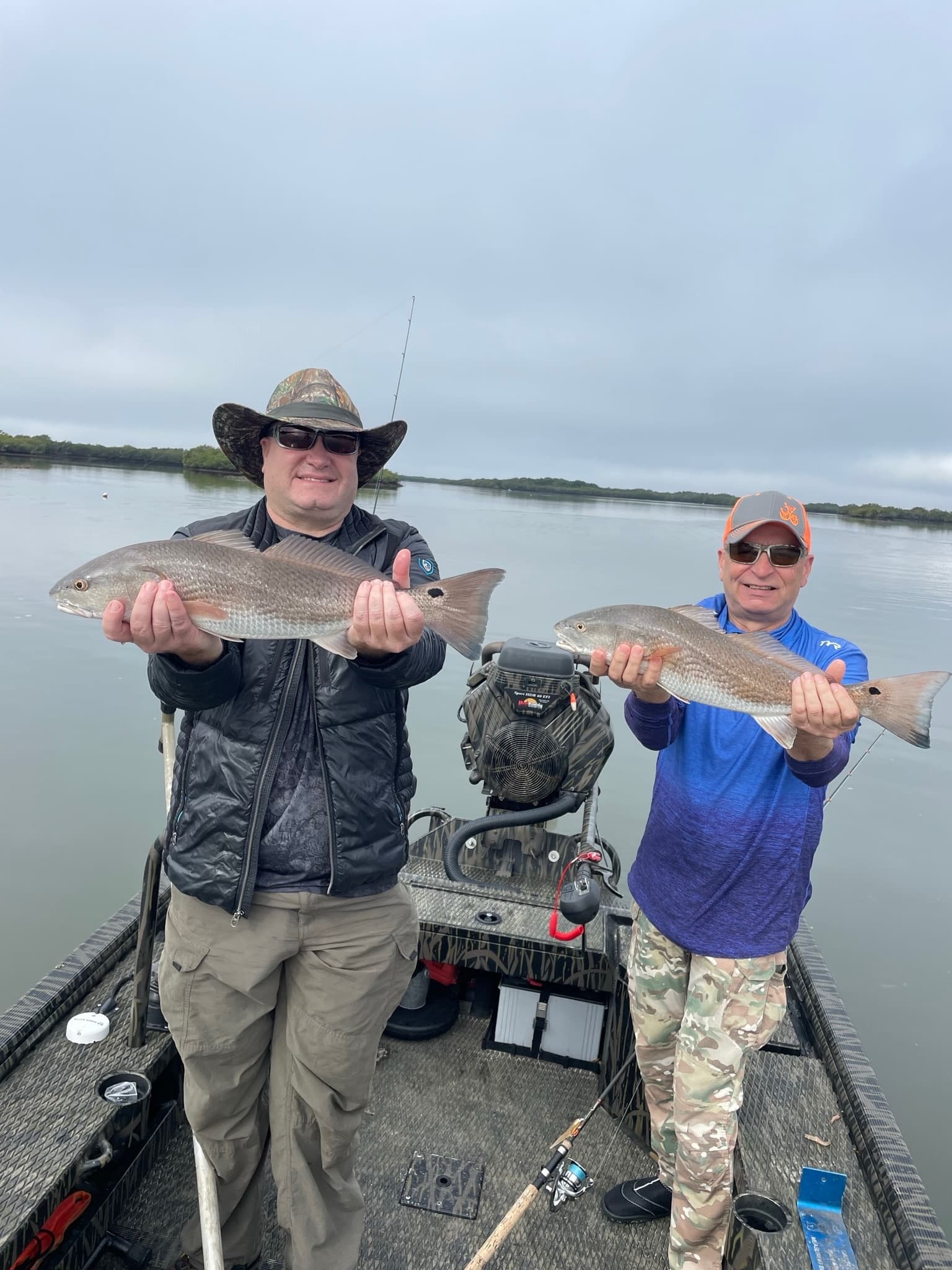 Two anglers posing with redfish on inshore estuary boat trip