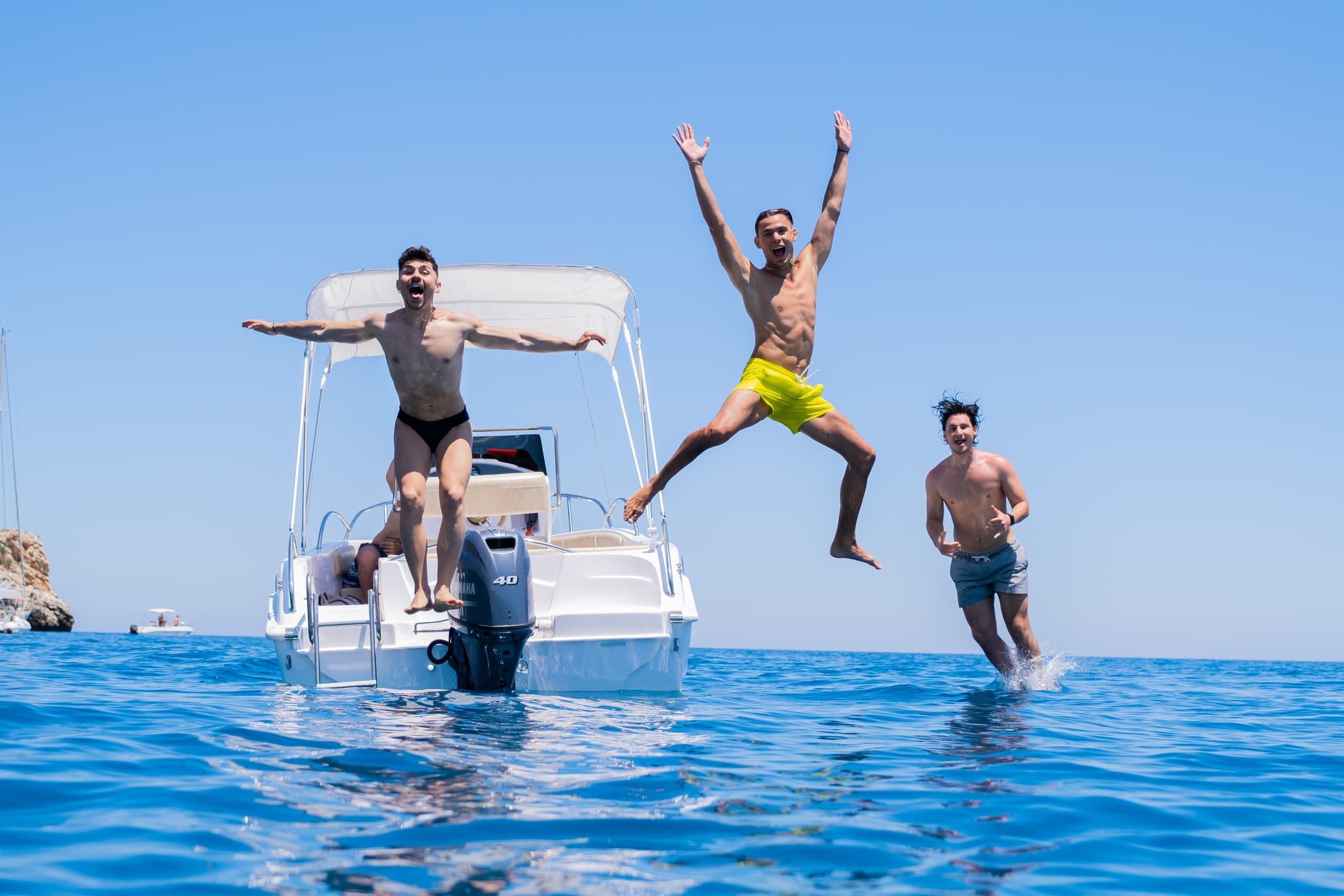 Boaters jumping into clear Mediterranean waters, Castellammare del Golfo