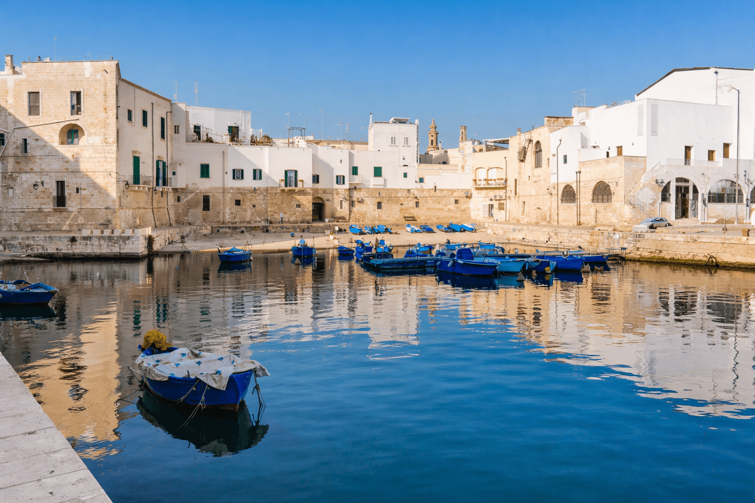 Sunny fishing harbor with colorful boats in calm Mediterranean bay