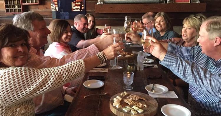 Friends clinking glasses during cozy indoor restaurant meal