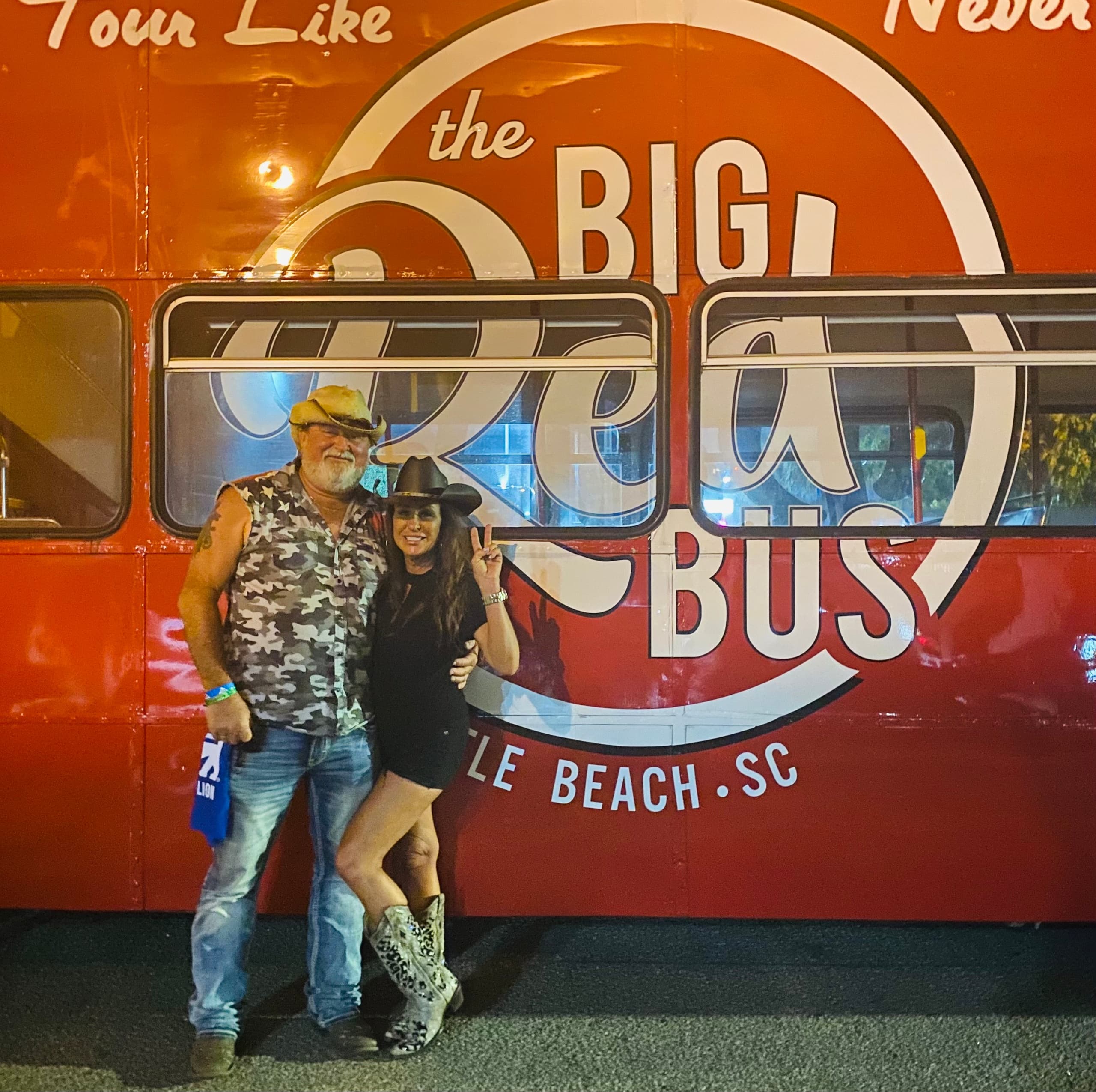 Couple posing by Big Red Bus exterior in Myrtle Beach tour photo