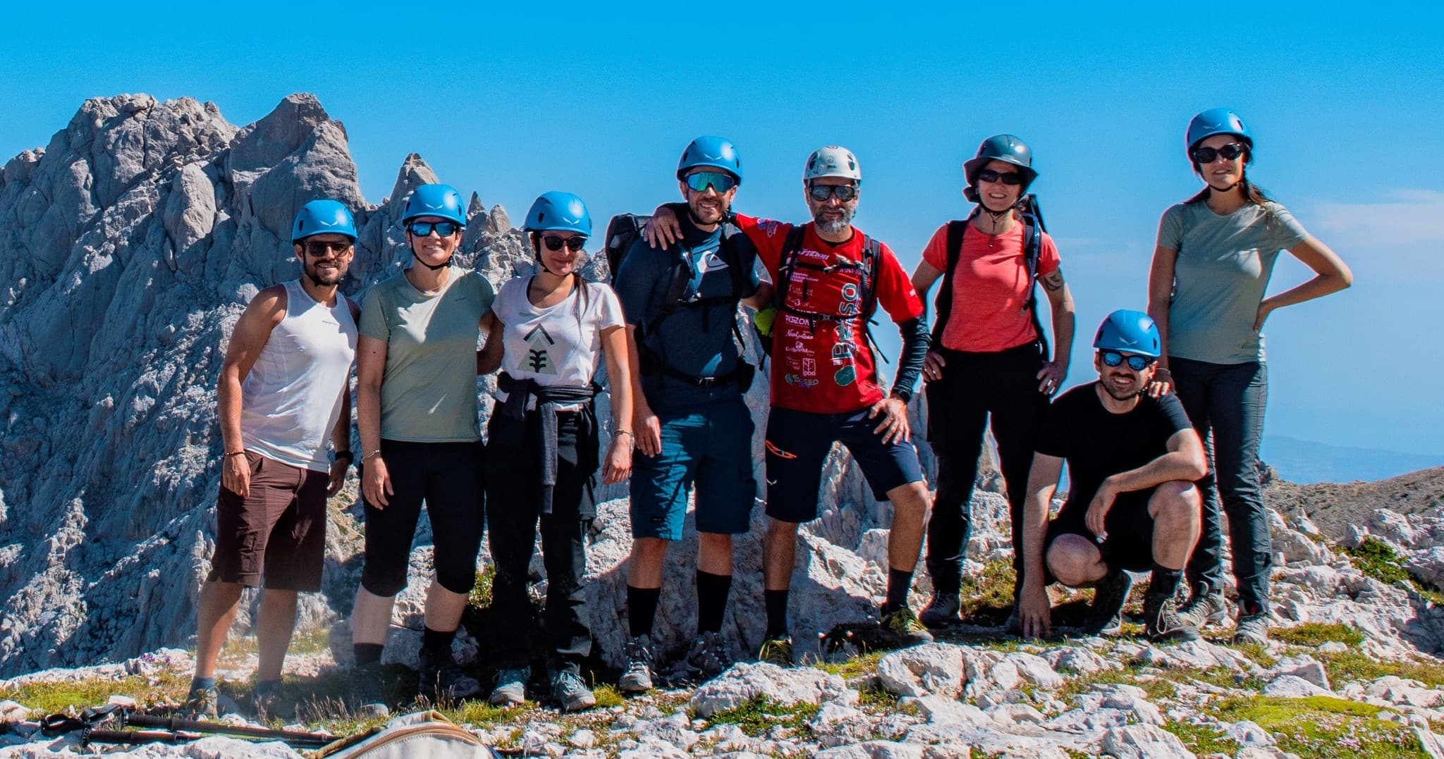 Group of climbers on rocky summit enjoying alpine vistas