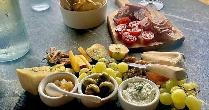 Cheese and antipasto platter with grapes for wine pairing