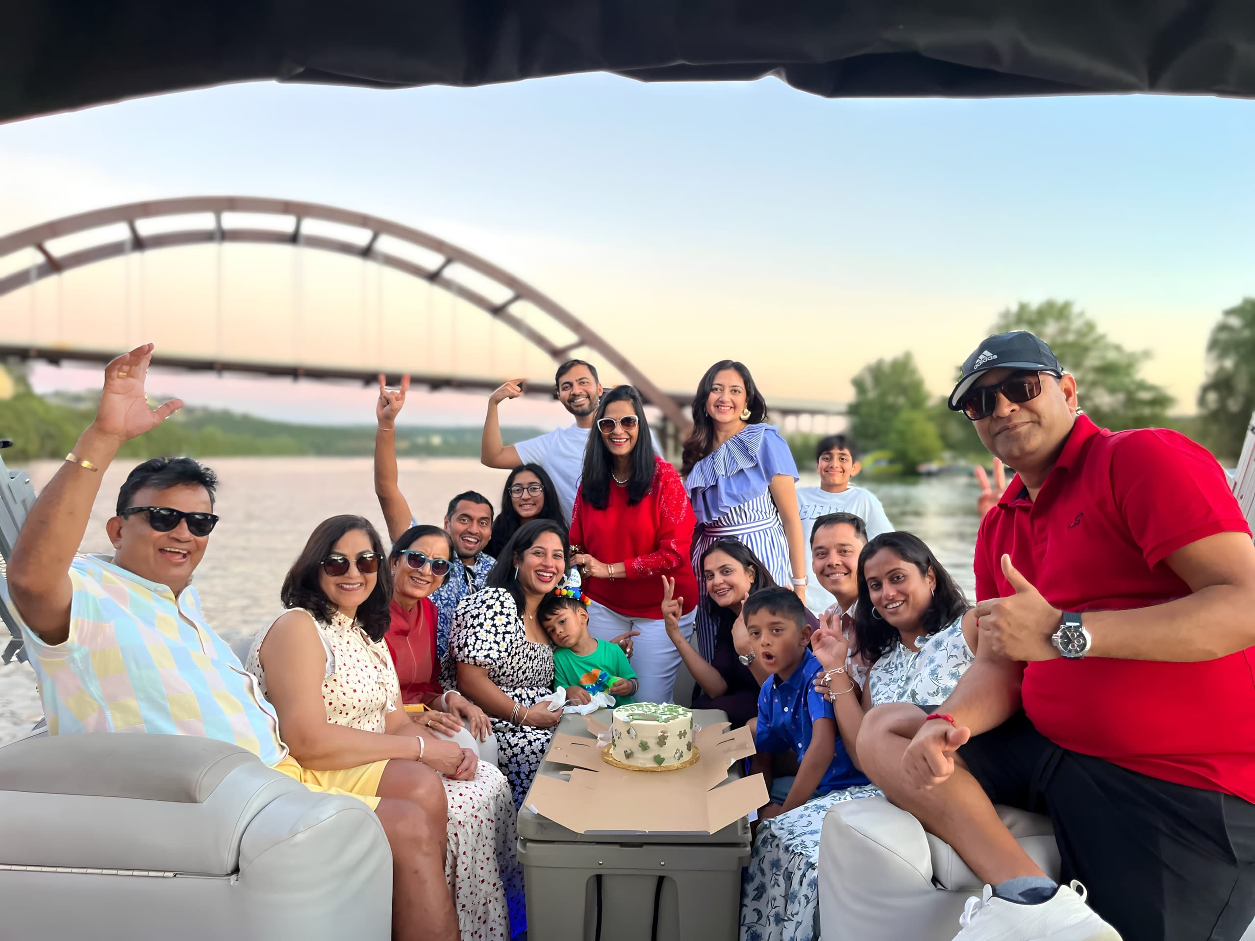 Large mixed-age group enjoying sunset boat cruise by bridge