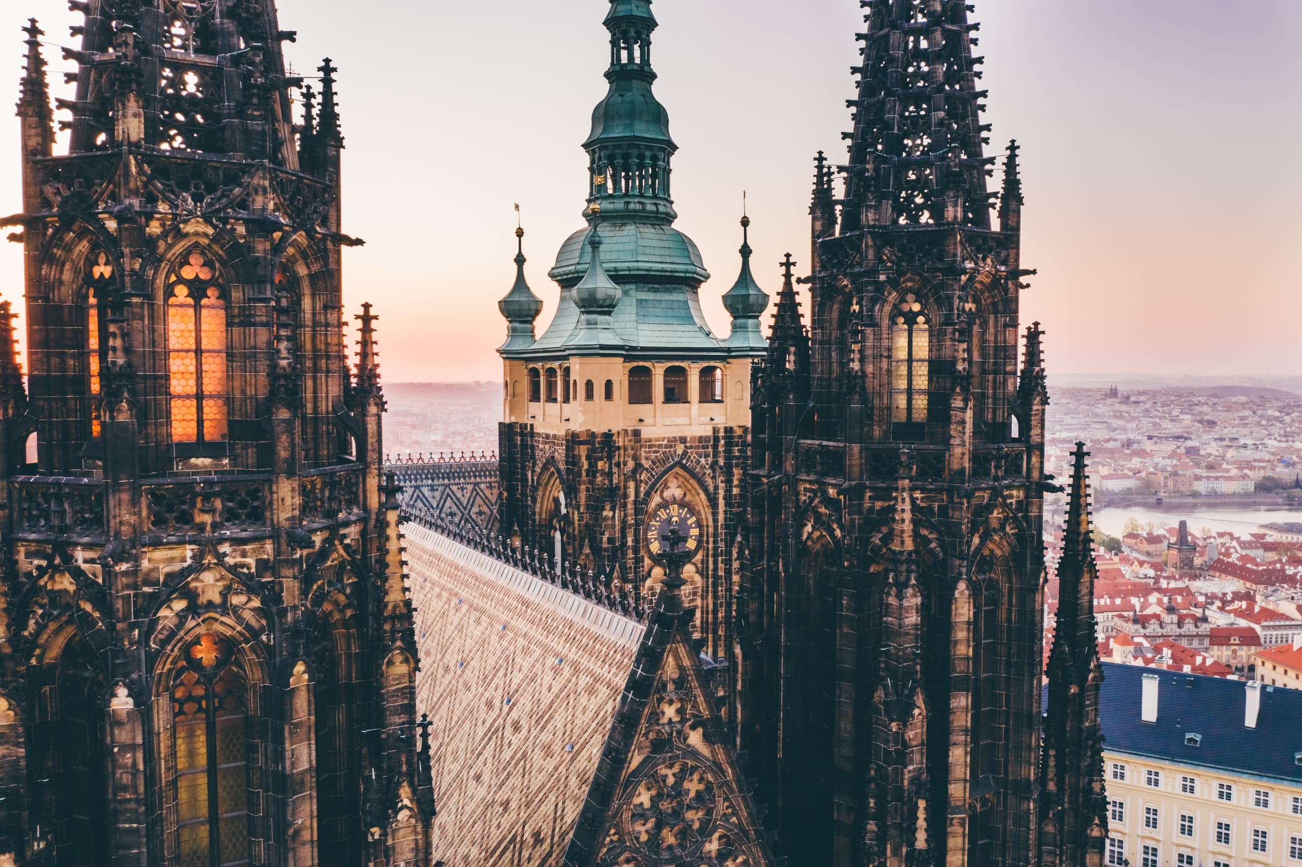 Gothic cathedral spires framing Prague skyline at golden hour