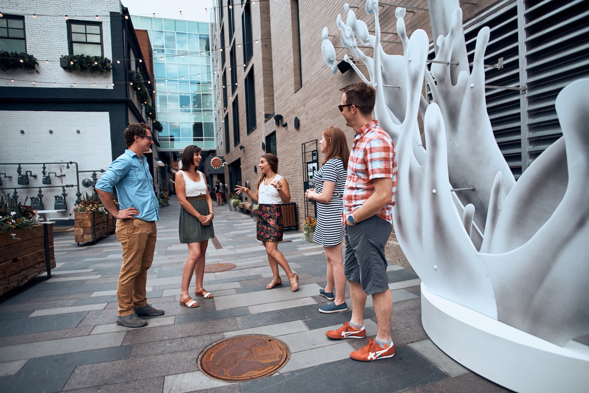 Friends on urban food tour near public sculpture in Denver