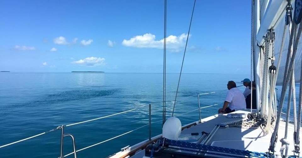 View from sailboat deck over clear blue sea during cruise