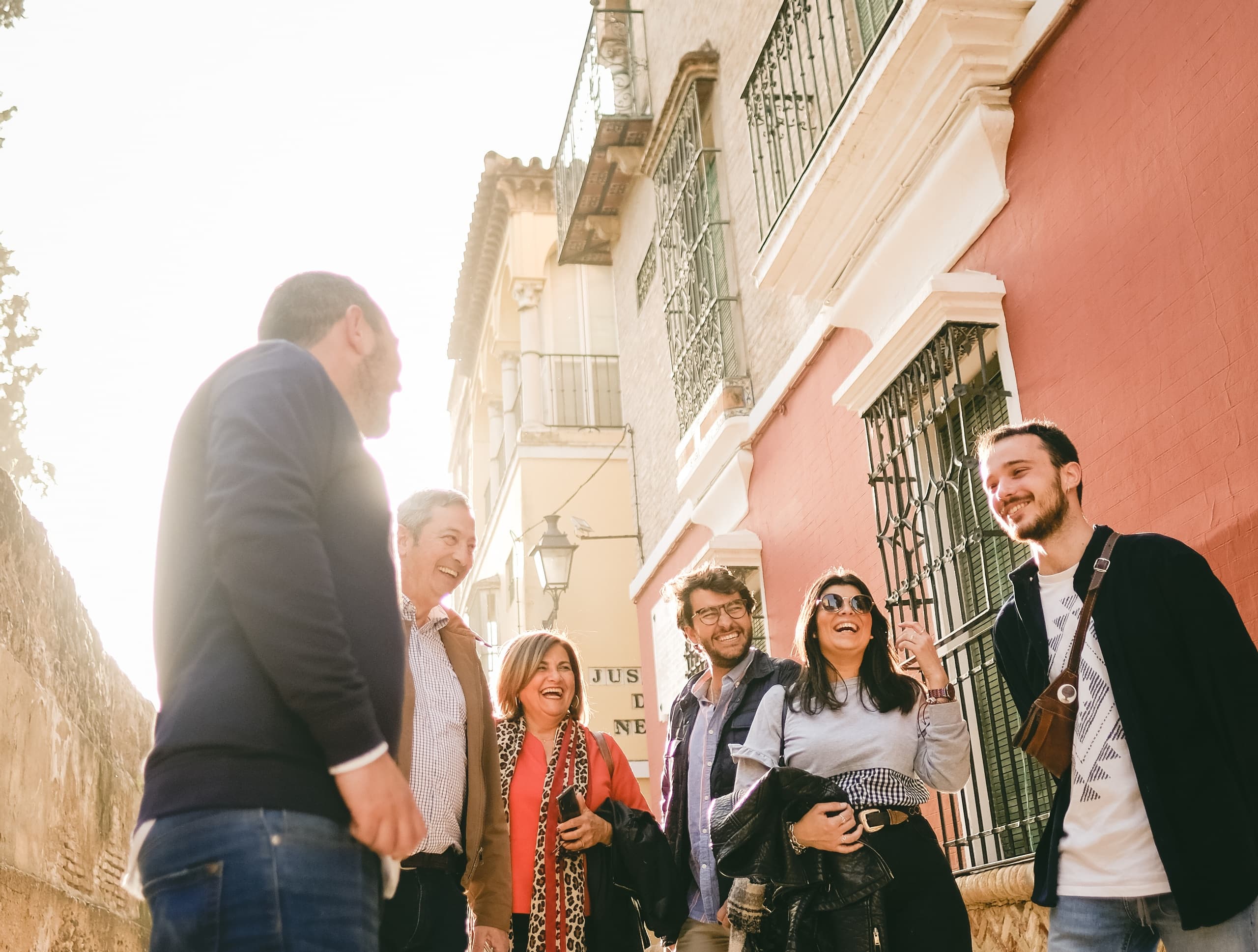 Guided walking tour group exploring colorful Seville streets