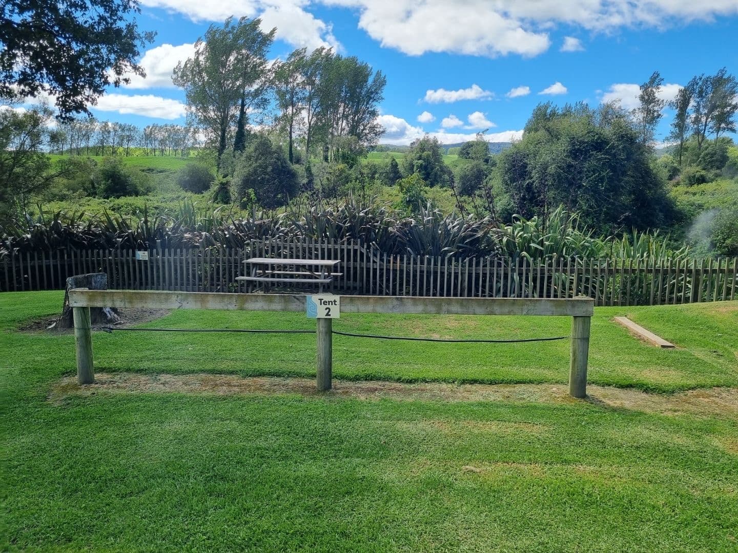 Riverside wooden fence and picnic benches overlooking river