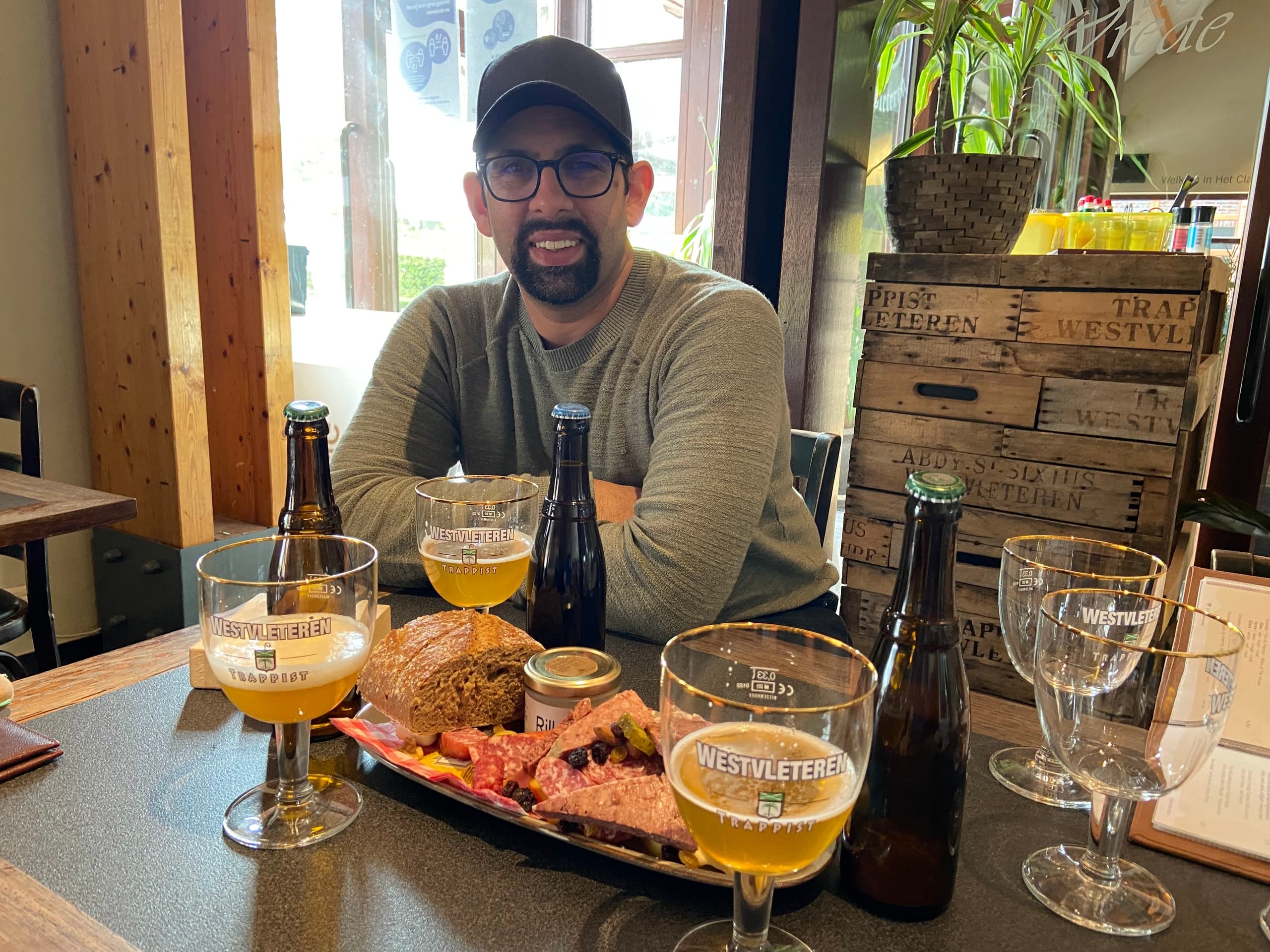 Man tasting Belgian beers with charcuterie in cozy cafe