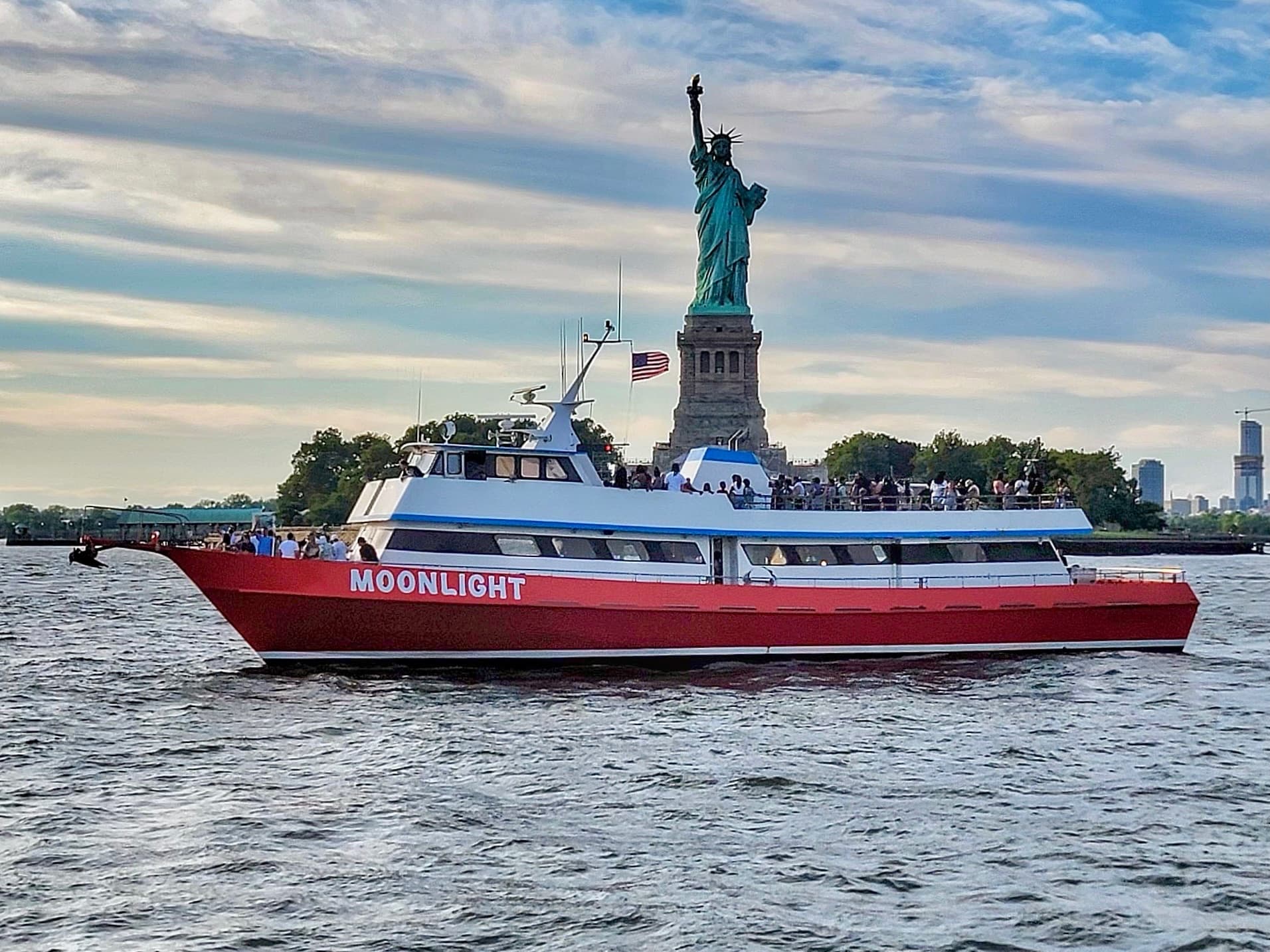 Tour boat close to Statue of Liberty with skyline views