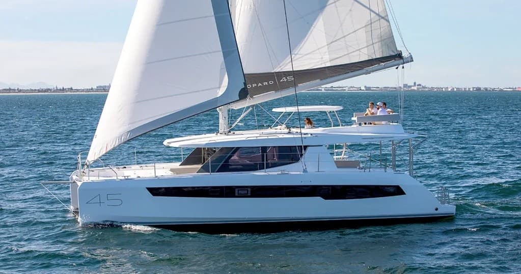 Catamaran sailing on open sea with coastal horizon view