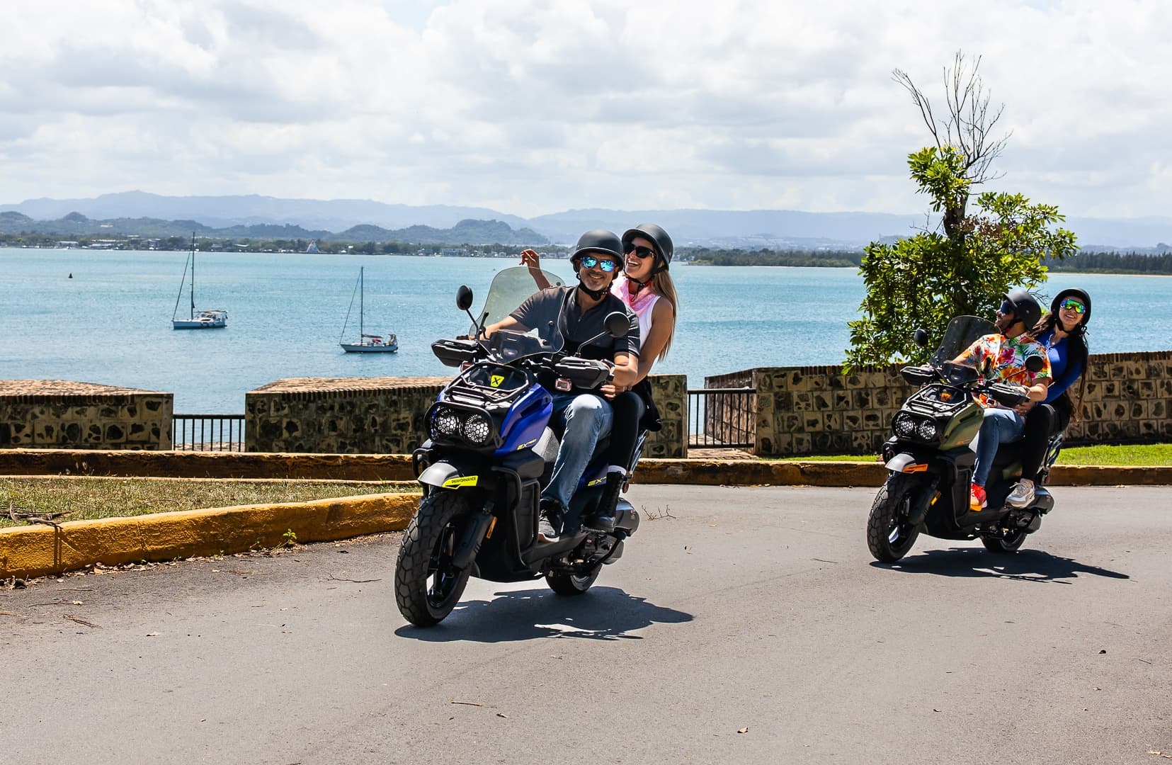 Couple scooter ride along seaside road in Puerto Rico