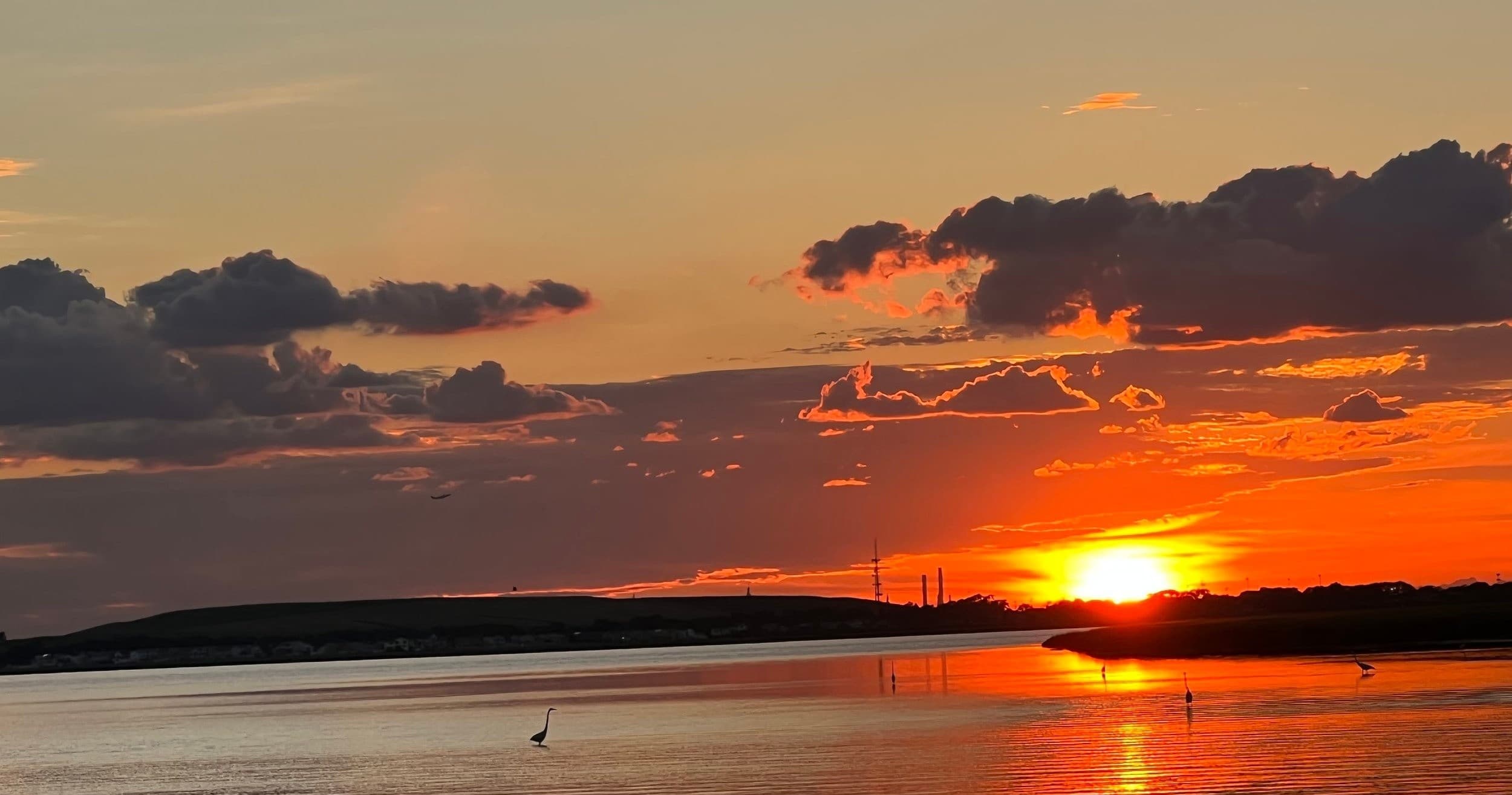 Coastal sunset over Freeport bay, tranquil shoreline reflections