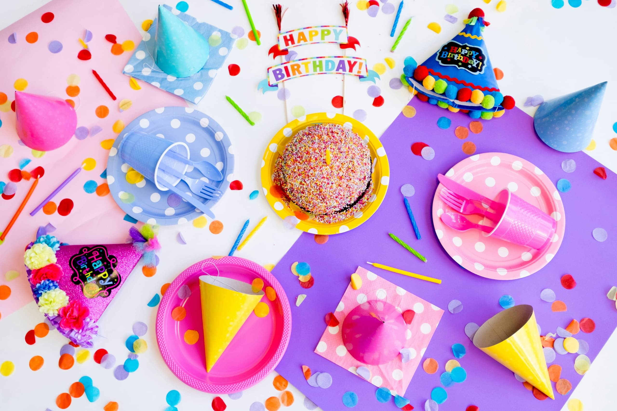Colorful birthday party flatlay with confetti and desserts