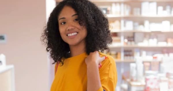 Smiling woman in Charlotte candle bar shop holding a bag