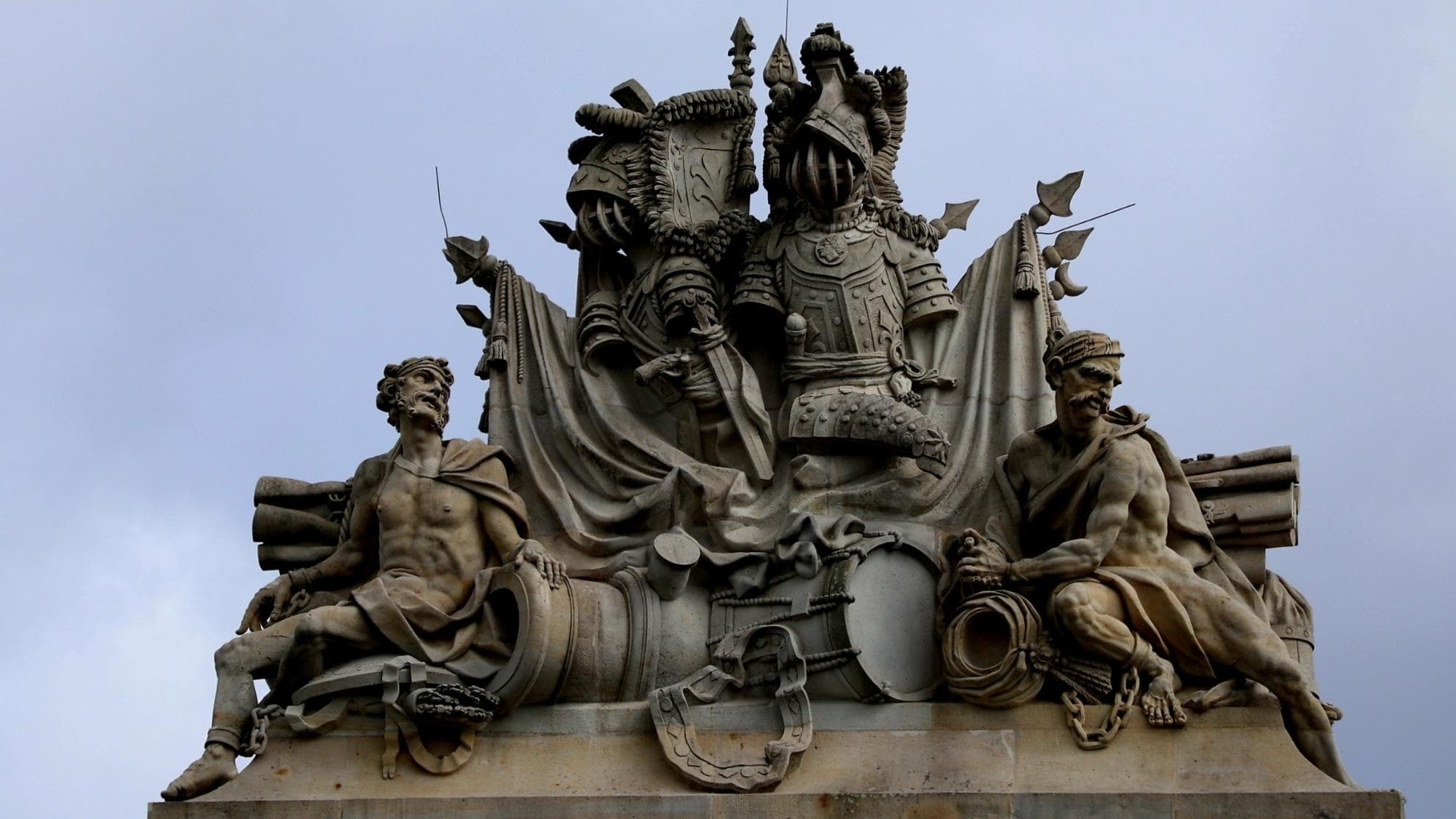 Ornate rooftop sculpture group against sky at park or plaza