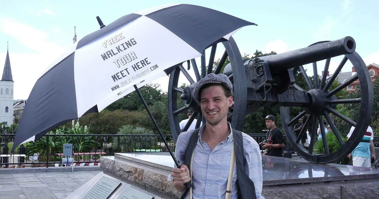 Tour guide holding umbrella by cannon at Jackson Square