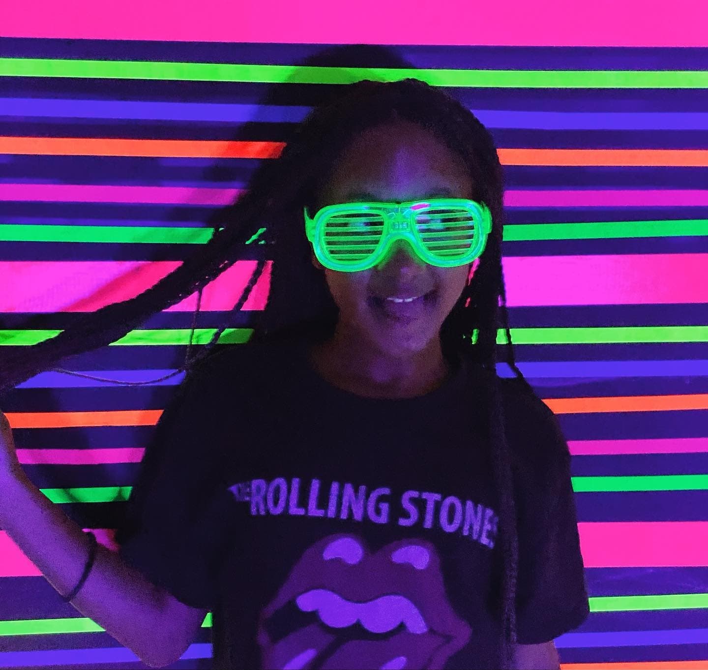 Neon striped backdrop portrait in selfie studio with glowing glasses