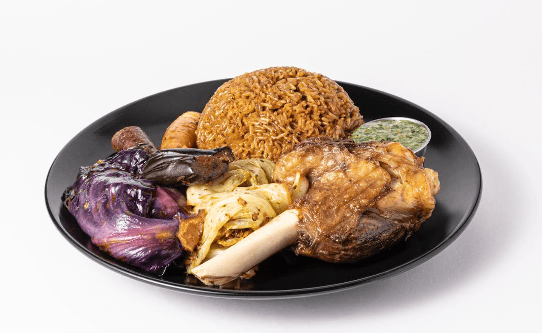 Jollof rice with grilled chicken and fried plantain on black plate