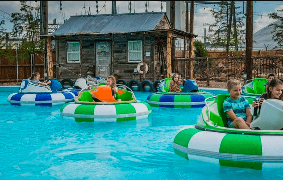 Bumper boats floating in outdoor pool with inflatable rings