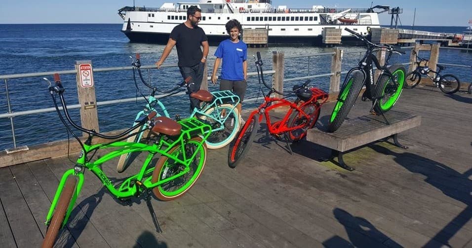 Group of colorful bikes dockside with ferry and ocean view