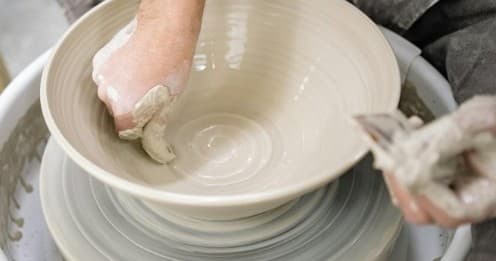 Close-up shaping bowl on pottery wheel in studio