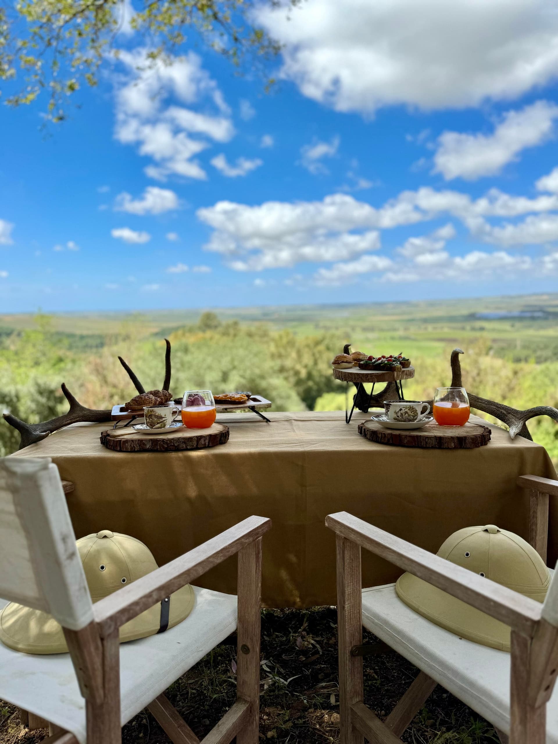 Rustic outdoor breakfast setup on deck with sweeping countryside view