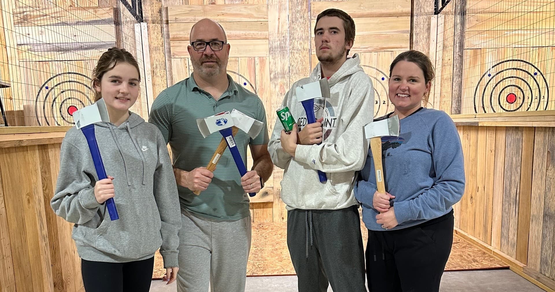 Family posing with axes at West Blount indoor axe throwing