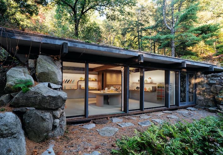 Modern glass house nestled among rocky woodland trails at Manitoga
