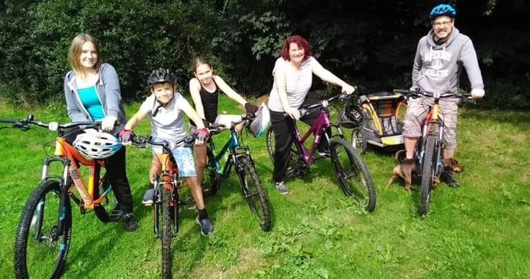 Group bike outing on grassy park meadow with helmets