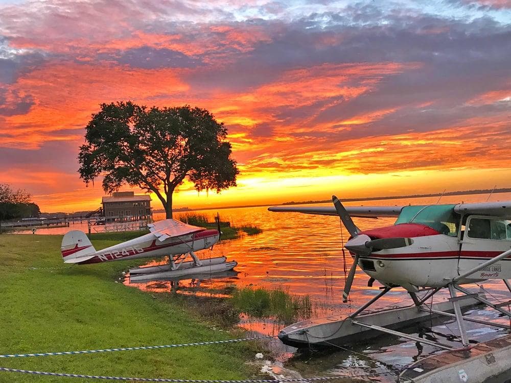 Sunset seaplanes parked on shoreline, scenic lakeside air tours