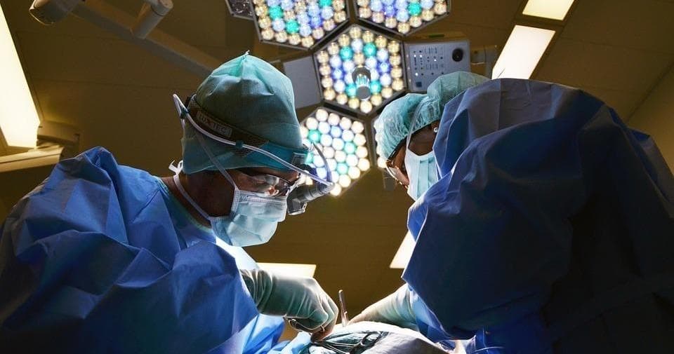 Surgeons performing an operation in a hospital operating room under lights