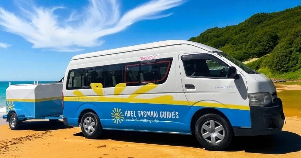 Abel Tasman tour van on golden beach showing coastal transfers