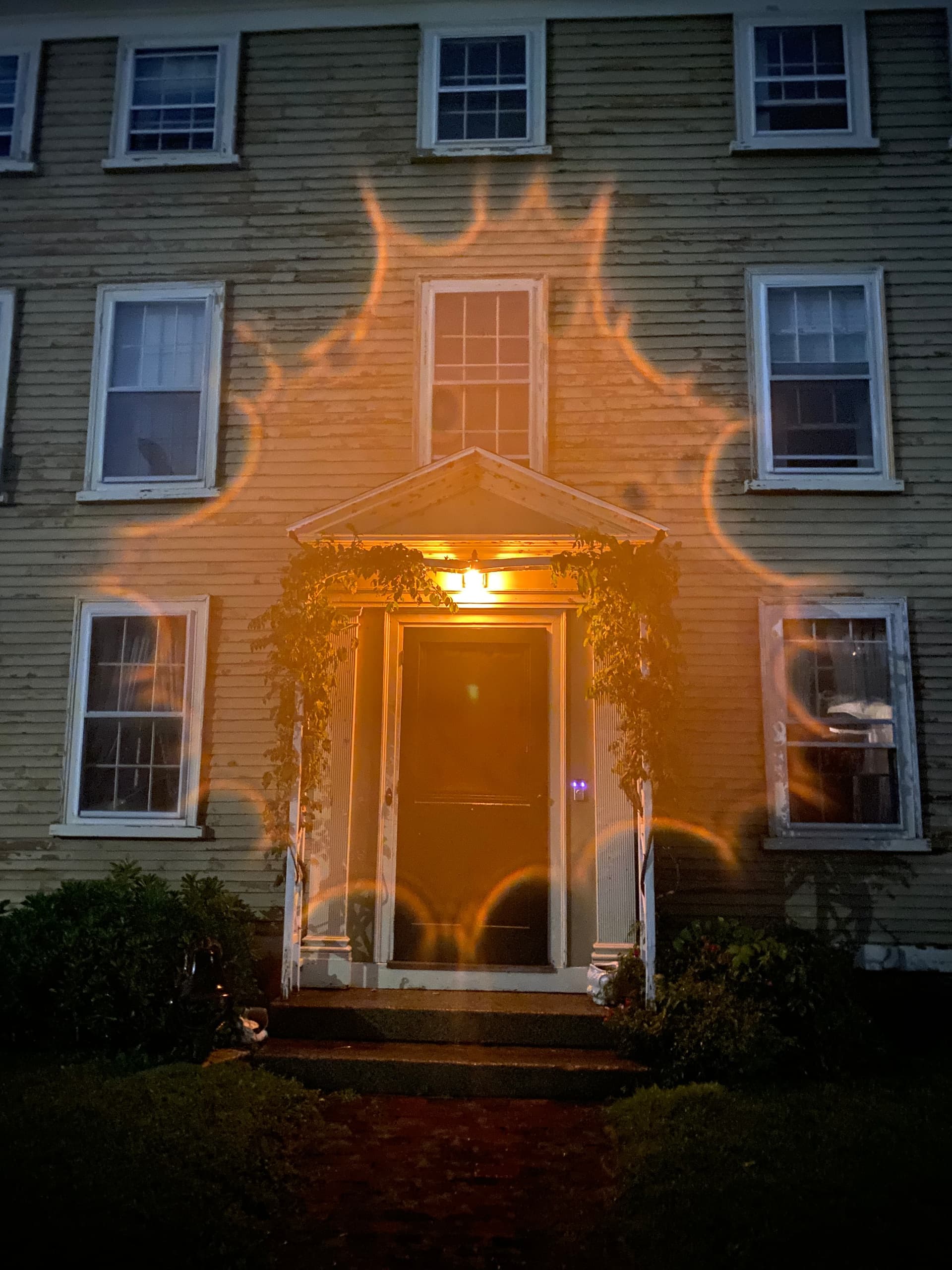 Old Salem house entrance illuminated with ghostly orange light
