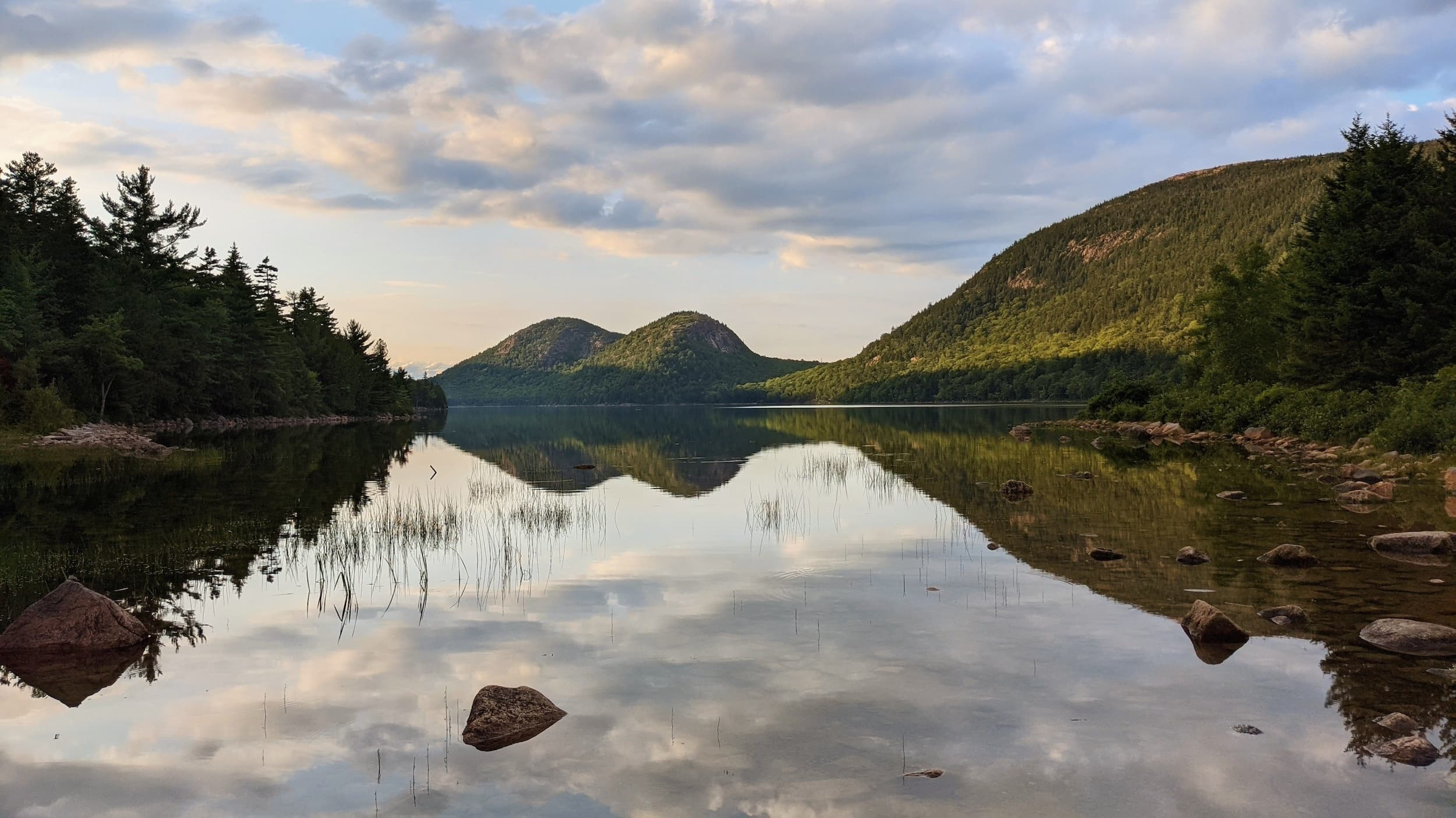 Mirror lake reflecting twin mountains at dawn, tranquil scenery