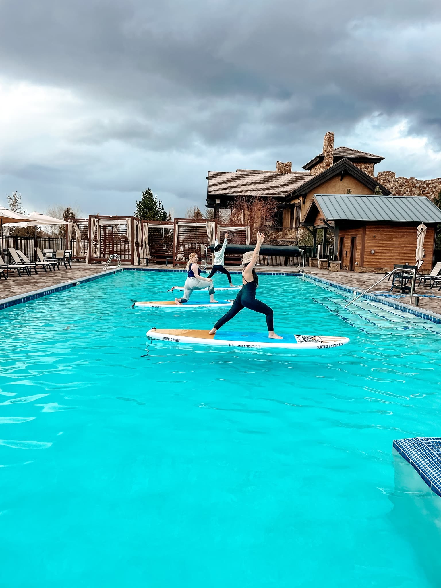Paddleboard yoga on resort pool in outdoor hotel setting balancing