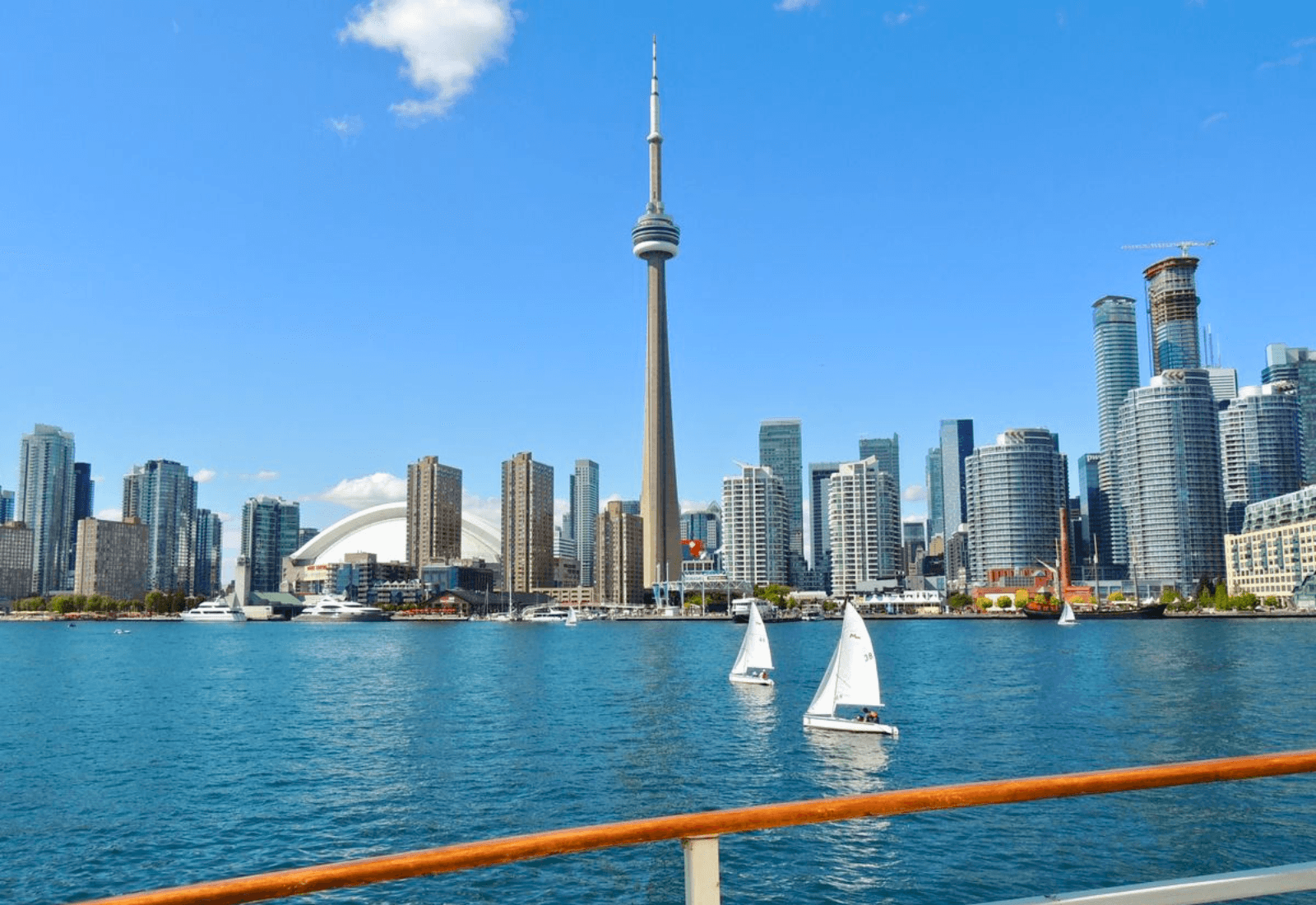 Toronto skyline view from lake with sailboats and CN Tower