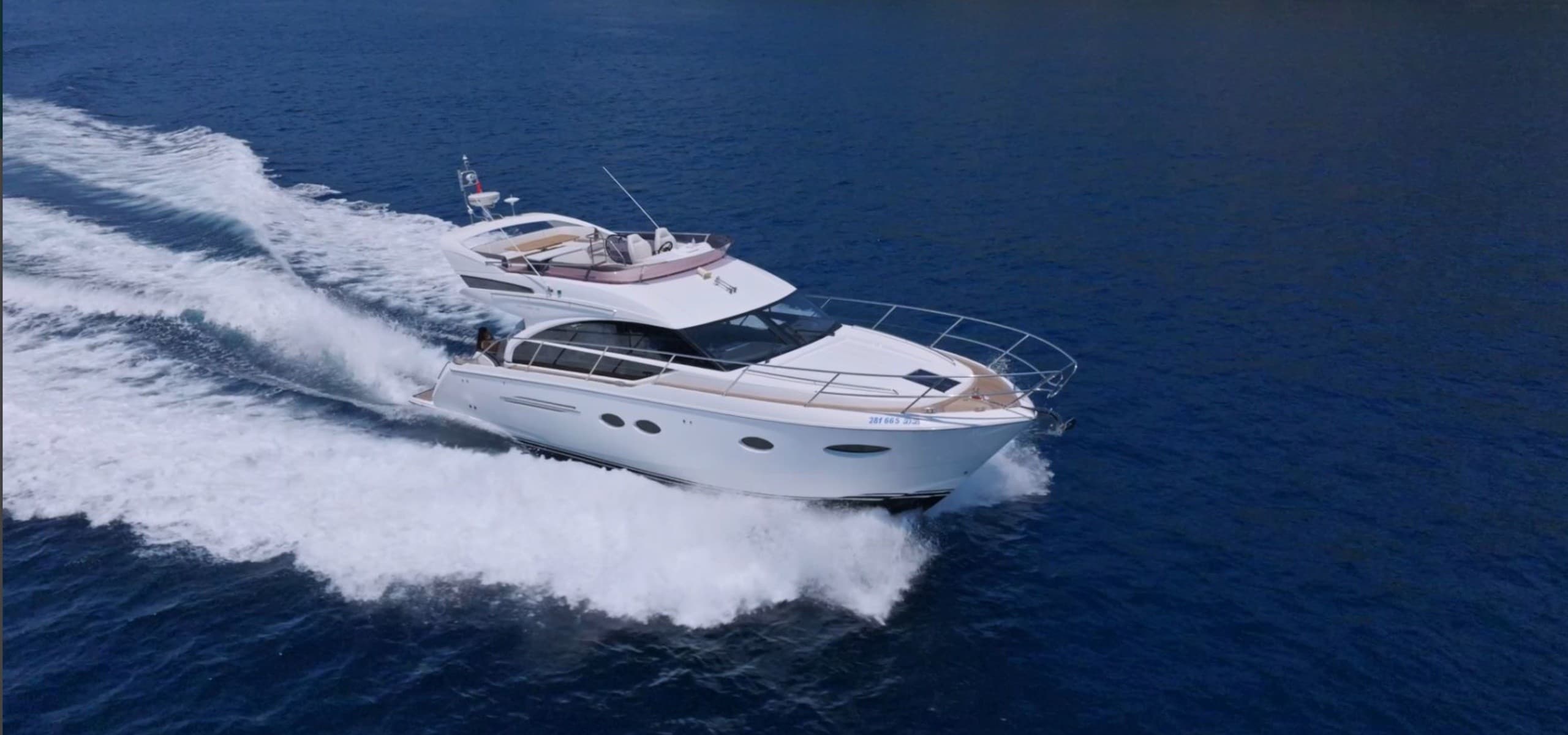 Motor yacht speeding across deep blue sea with spray