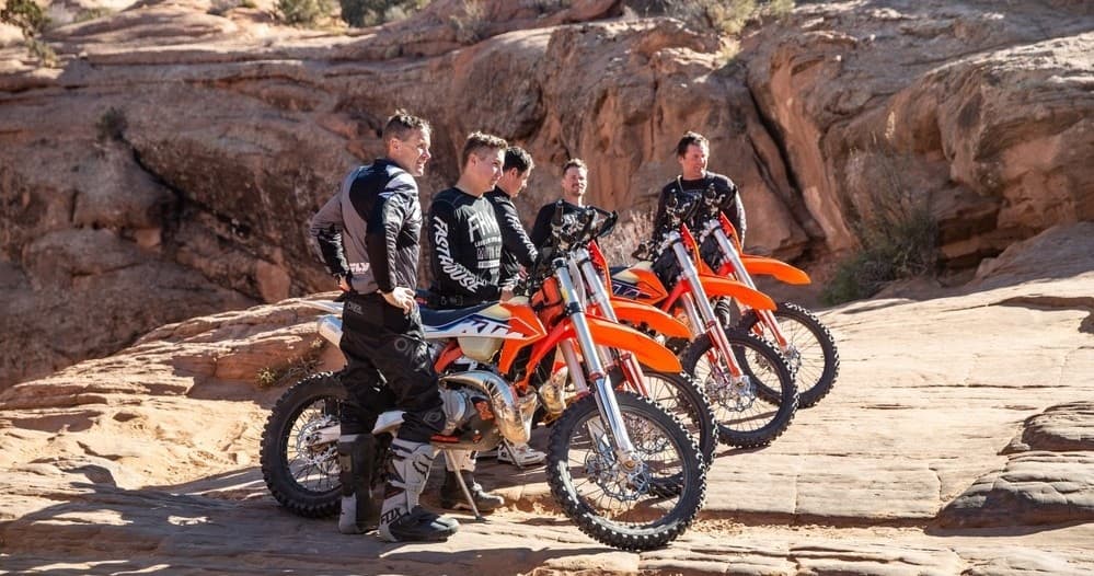 Group of riders pausing on red rock ledge in Moab, Utah