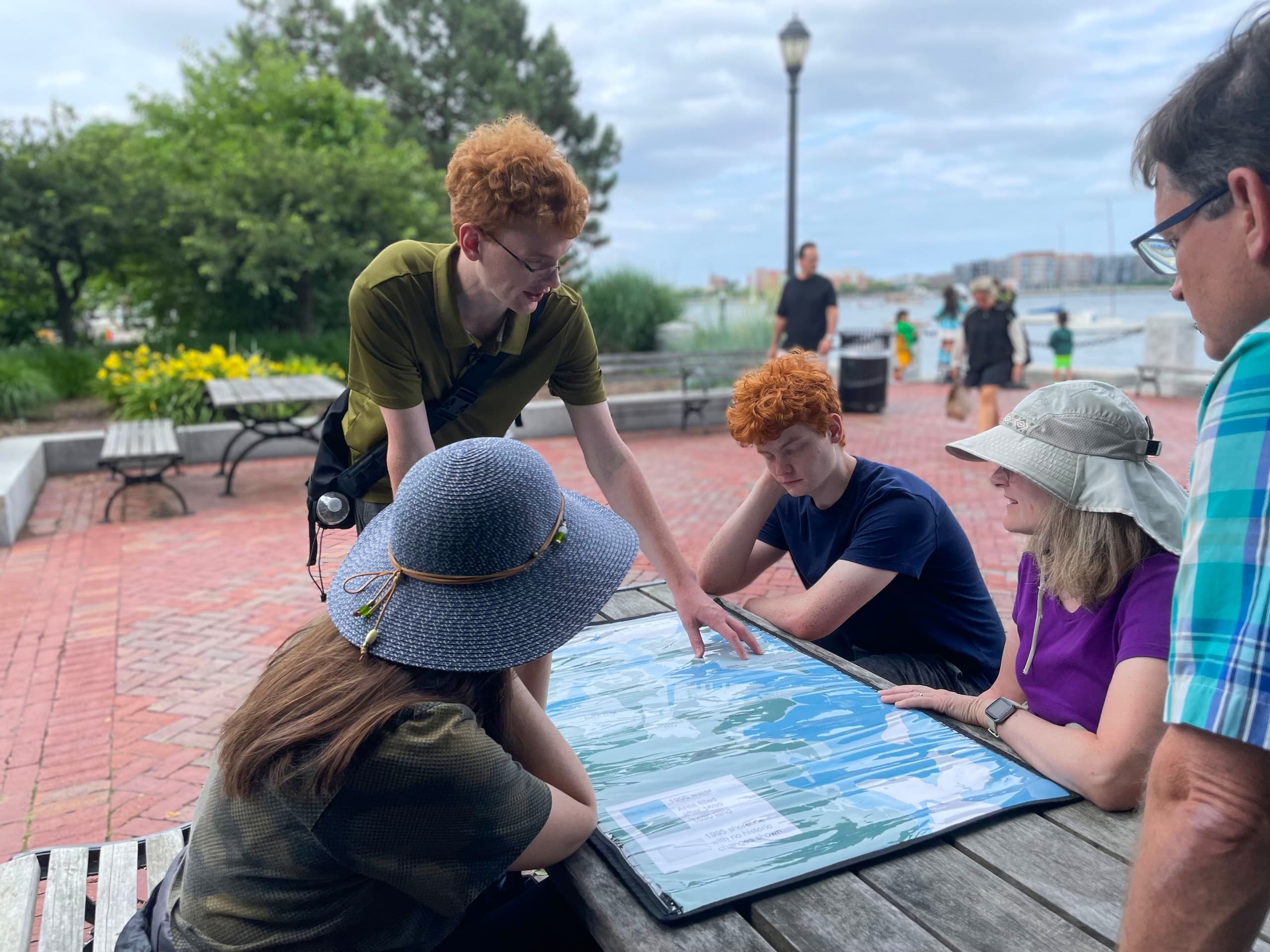 Group examining waterfront map during Boston outdoor history tour