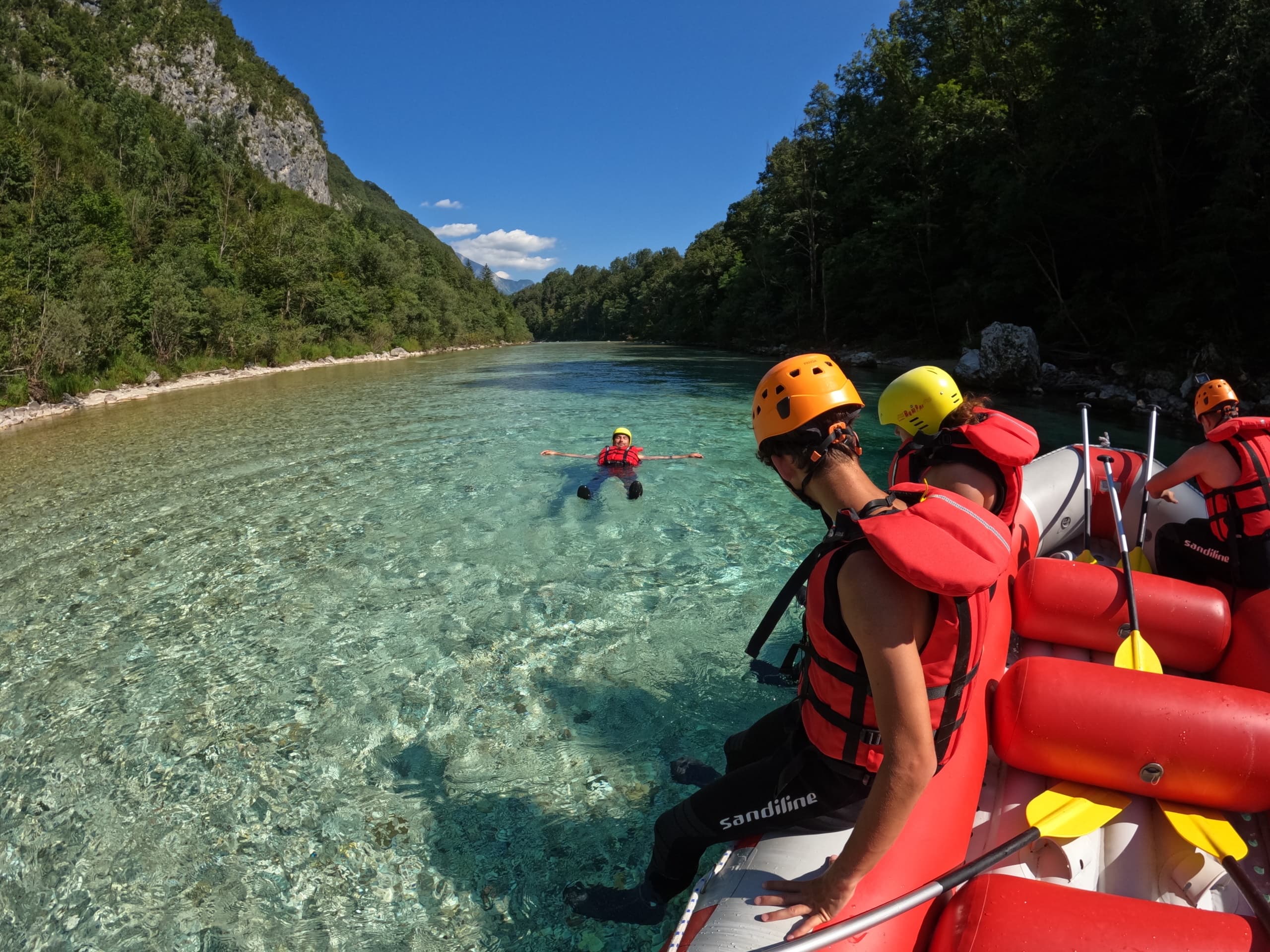 Rafting on crystal Soca River with guides and alpine mountains