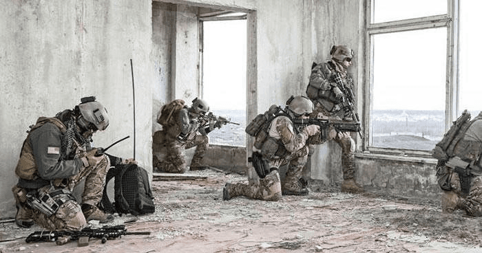 Tactical team clearing abandoned urban building during outdoor operation