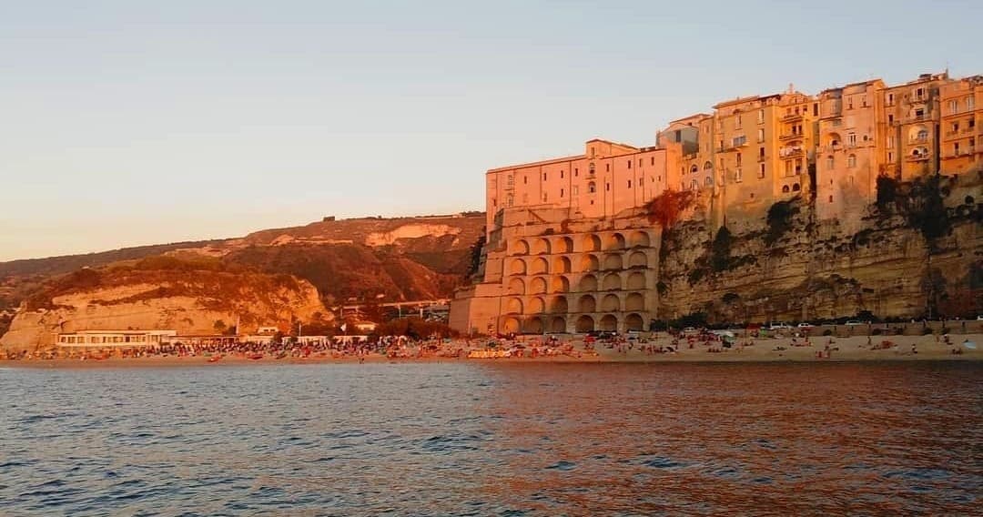 Historic coastal town cliffs lit at golden hour over sea