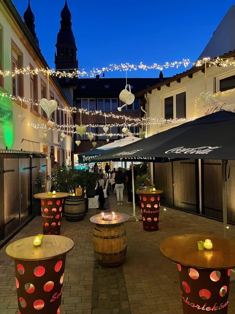 Outdoor evening courtyard dining under string lights in Speyer