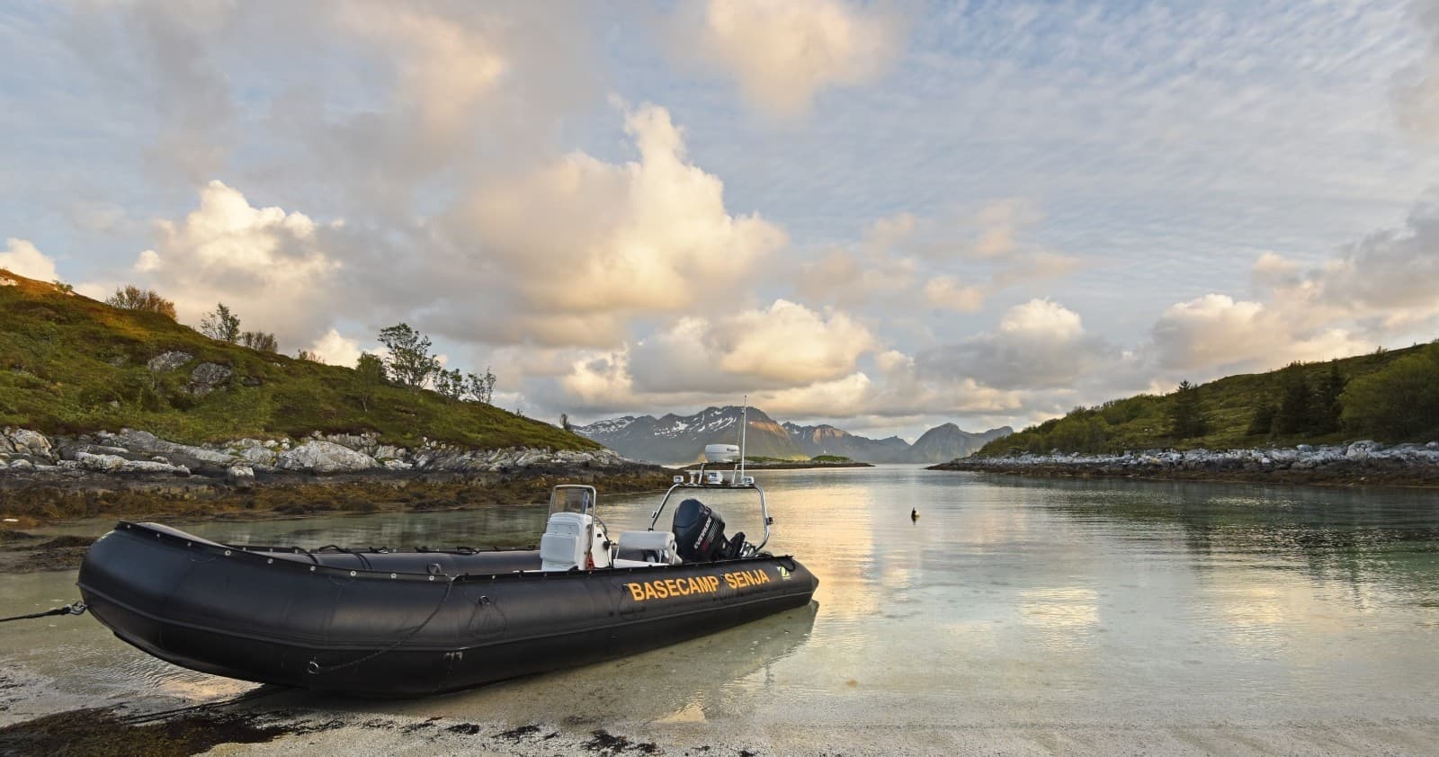 Rigid-inflatable boat moored in coastal inlet at golden hour
