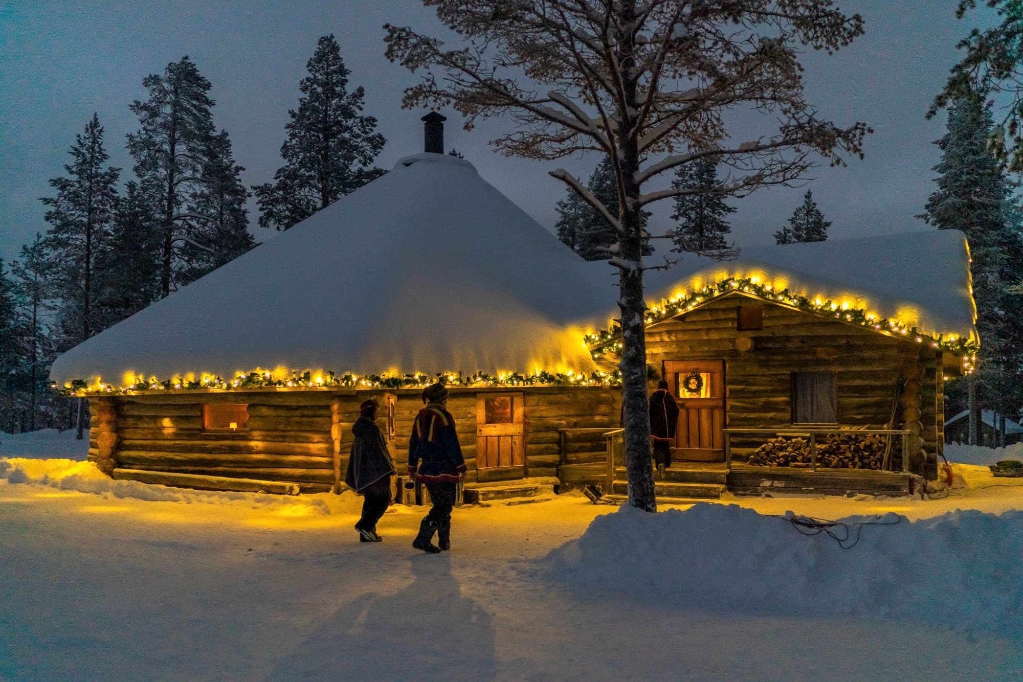 Cozy illuminated wilderness cabin at dusk in Saariselkä, Lapland
