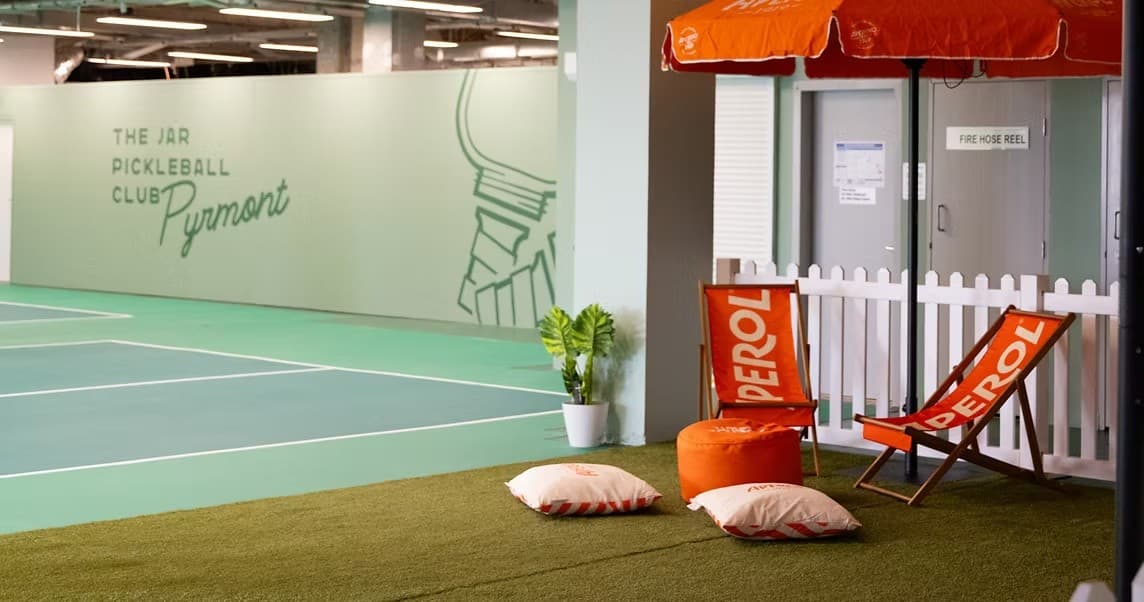 Empty indoor pickleball court at The Jar Pyrmont with lounge