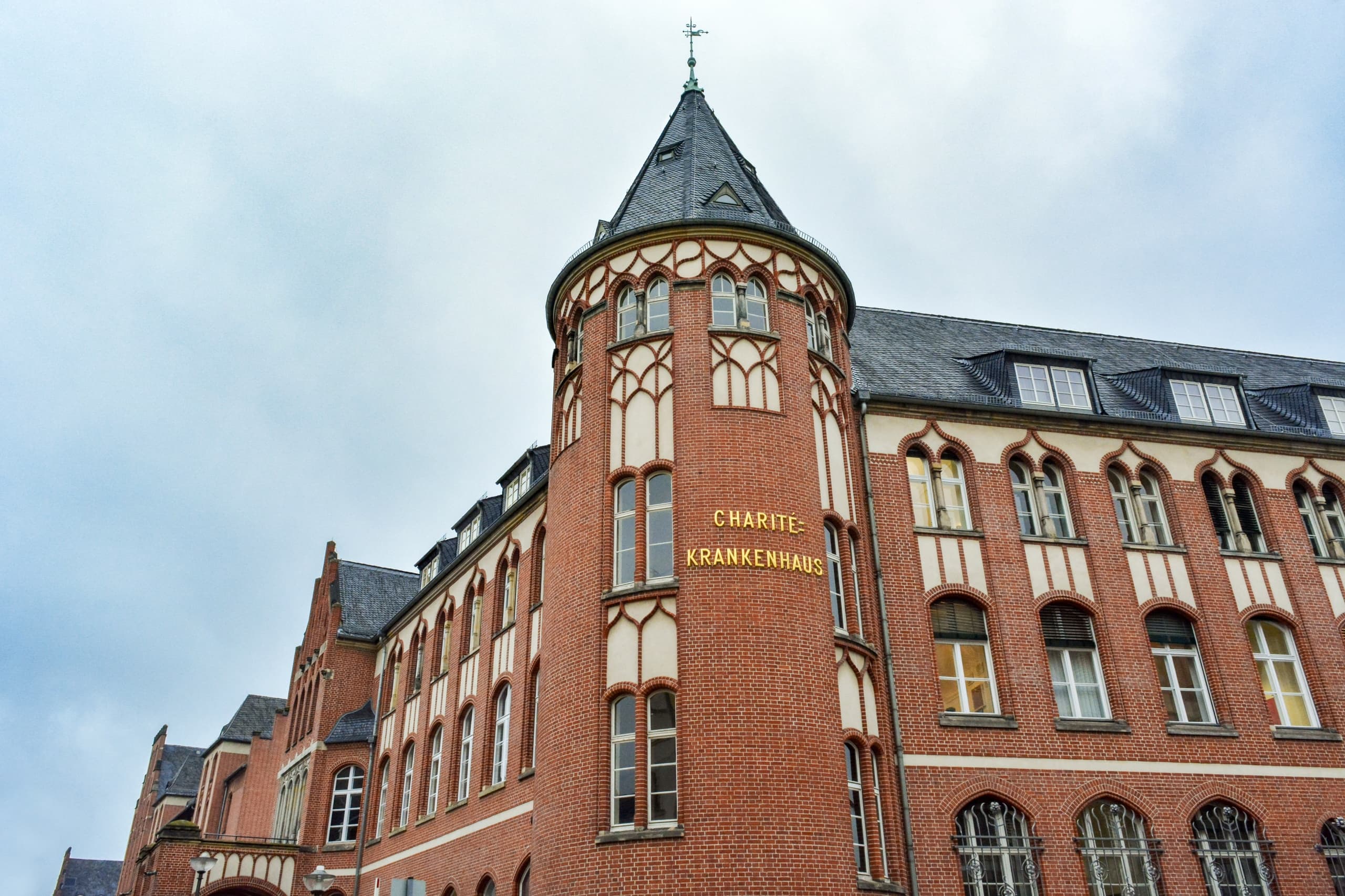 Wide-angle red brick urban architecture with turret and sky